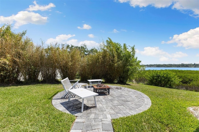 view of yard with a water view, a patio area, and a fire pit
