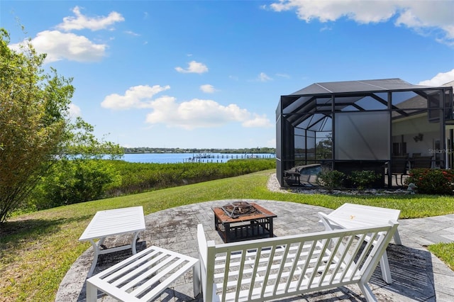 view of patio featuring glass enclosure, a water view, and an outdoor fire pit