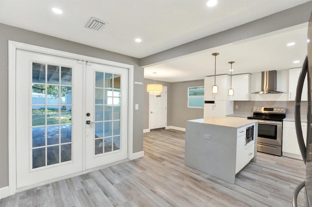 4310 S Coolidge Ave, Tampa, FL 33611 - kitchen with visible vents, wall chimney range hood, built in microwave, stainless steel electric stove, and french doors