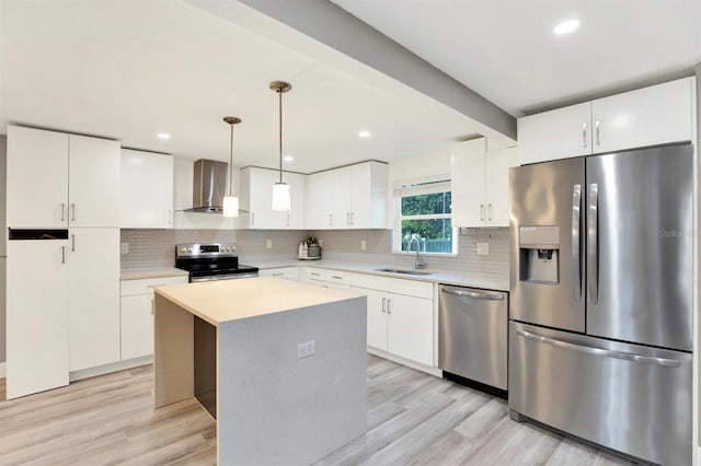 4310 S Coolidge Ave, Tampa, FL 33611 - kitchen featuring stainless steel appliances, light wood-style floors, wall chimney exhaust hood, and tasteful backsplash