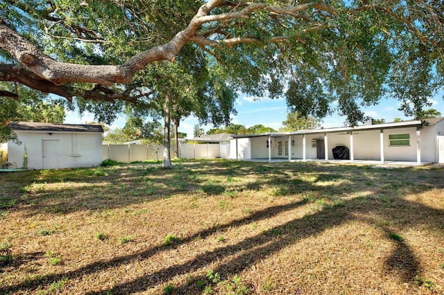 4310 S Coolidge Ave, Tampa, FL 33611 - view of yard featuring a patio area, fence, an outbuilding, and a shed