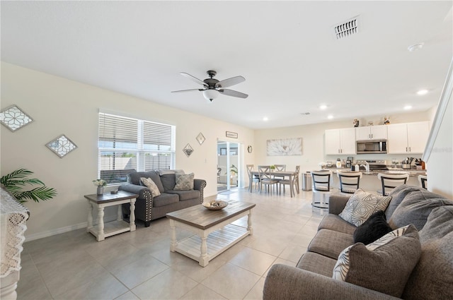 living area featuring light tile patterned flooring, ceiling fan, recessed lighting, baseboards, and visible vents