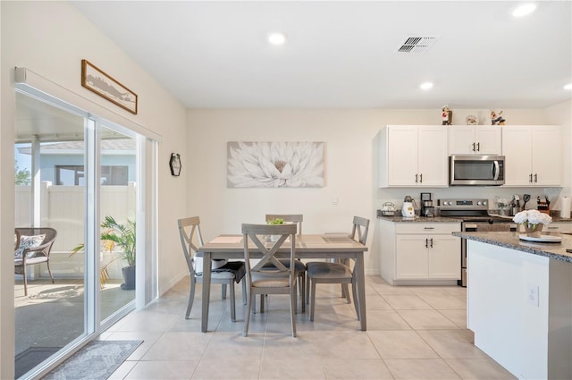 kitchen featuring visible vents, stone countertops, white cabinetry, light tile patterned floors, and stainless steel appliances
