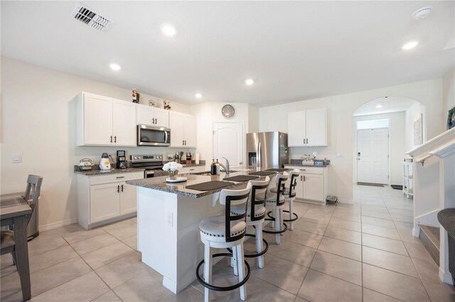 kitchen with visible vents, a breakfast bar area, light tile patterned flooring, and stainless steel appliances