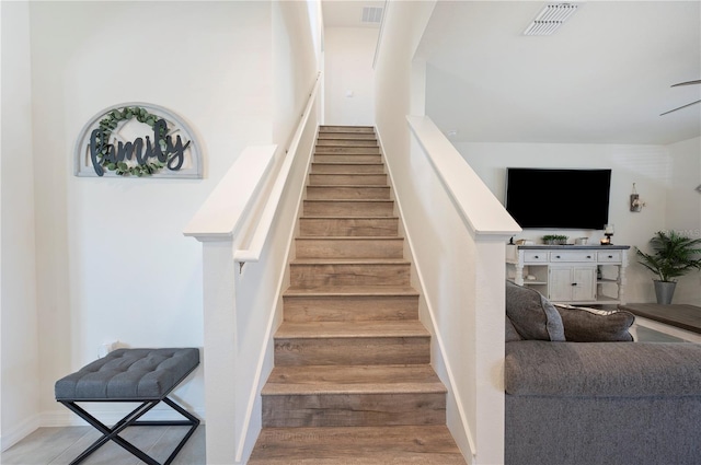 staircase featuring visible vents and wood finished floors