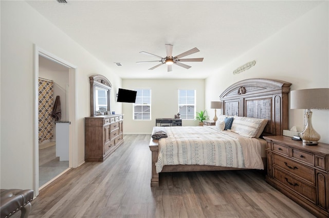 bedroom with visible vents, a ceiling fan, light wood-style flooring, and multiple windows