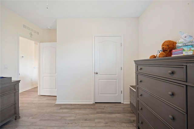 bedroom with baseboards, visible vents, and light wood-type flooring