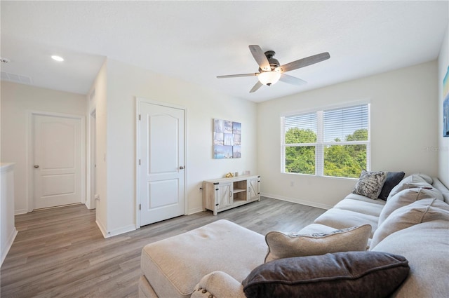 living room with a ceiling fan, visible vents, baseboards, light wood finished floors, and recessed lighting