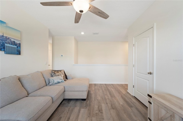 living room with a ceiling fan, baseboards, visible vents, and wood finished floors
