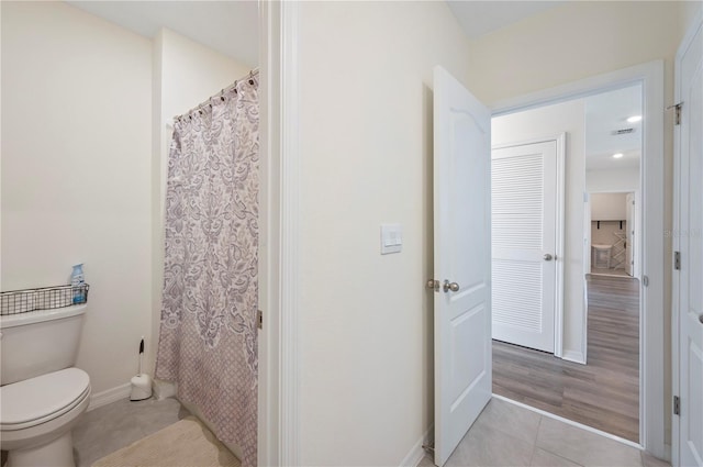 full bathroom featuring tile patterned flooring, visible vents, toilet, baseboards, and a shower with curtain