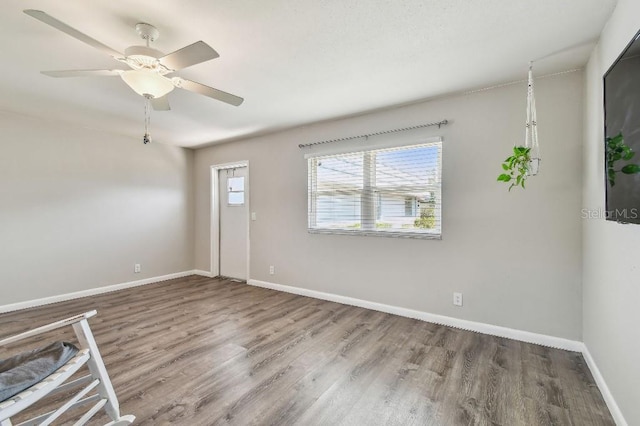 interior space featuring baseboards, ceiling fan, and wood finished floors