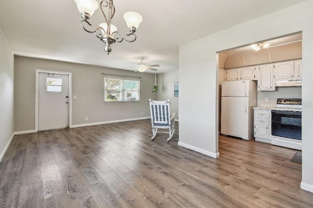 kitchen featuring freestanding refrigerator, white cabinets, wood finished floors, and electric range oven