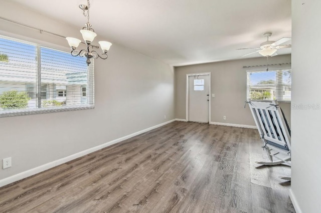 entrance foyer featuring baseboards, wood finished floors, and ceiling fan with notable chandelier