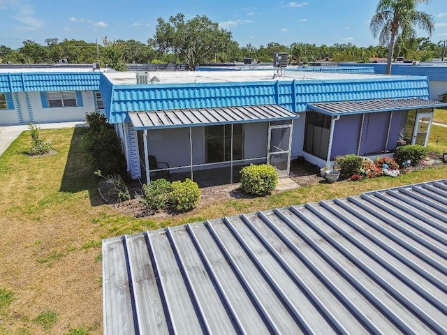 back of property with a sunroom and a yard