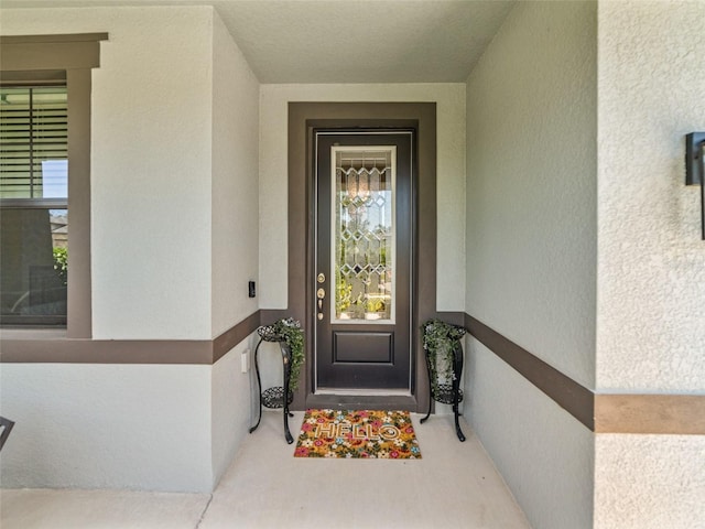 view of exterior entry with stucco siding