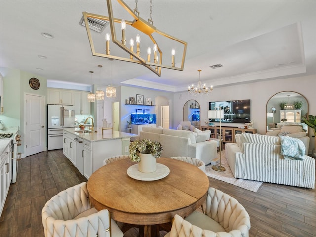 dining area featuring crown molding, visible vents, dark wood-style floors, and a chandelier