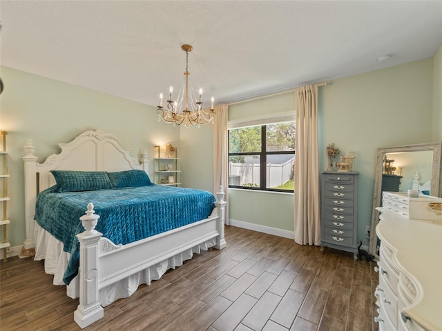 bedroom with baseboards, dark wood finished floors, and an inviting chandelier