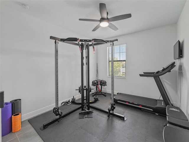 workout room featuring baseboards and ceiling fan
