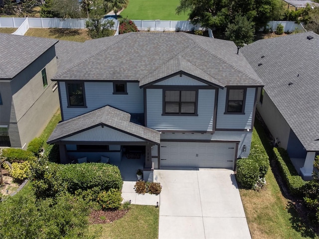 craftsman-style house with a garage, roof with shingles, fence, and driveway