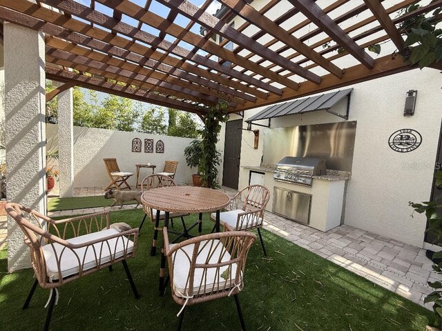 view of patio / terrace with a pergola, exterior kitchen, grilling area, and fence