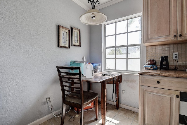 dining room featuring crown molding, baseboards, a textured wall, and light tile patterned flooring