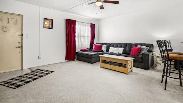 living area featuring a ceiling fan, a textured ceiling, and light colored carpet