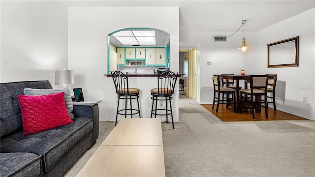 living area featuring light carpet and visible vents