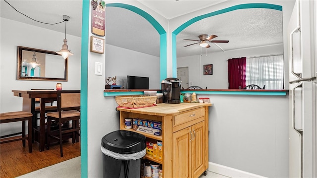 kitchen with a textured ceiling, ceiling fan, and butcher block counters