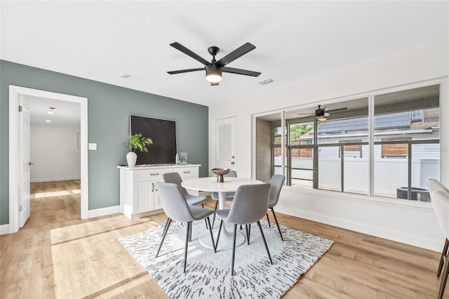 dining space featuring a ceiling fan, baseboards, and light wood-style floors
