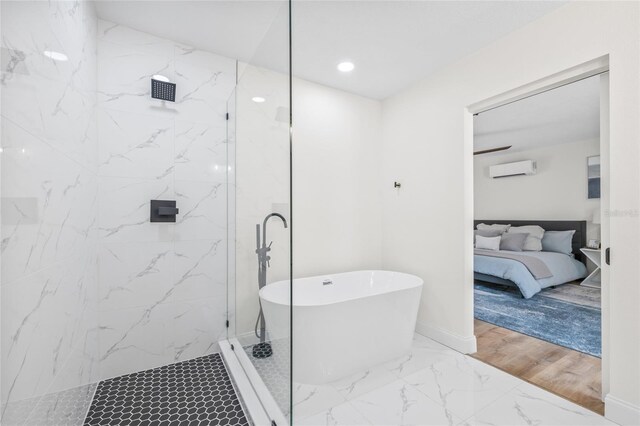 full bathroom featuring marble finish flooring, a freestanding tub, a marble finish shower, a wall unit AC, and ensuite bathroom
