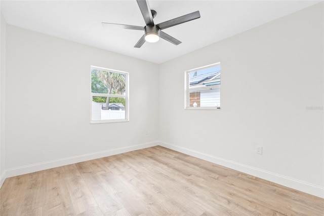 spare room with light wood-style floors, baseboards, and a ceiling fan