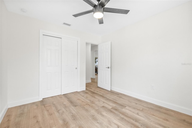 unfurnished bedroom featuring light wood-type flooring, a closet, baseboards, and a ceiling fan