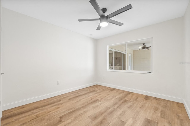 spare room with light wood-style floors, baseboards, and a ceiling fan