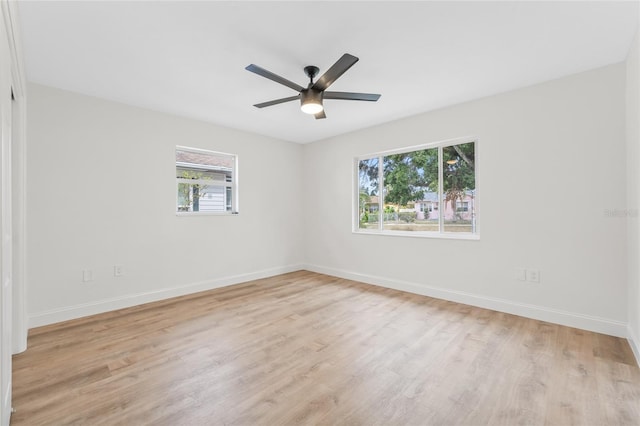 spare room featuring light wood finished floors, baseboards, and ceiling fan