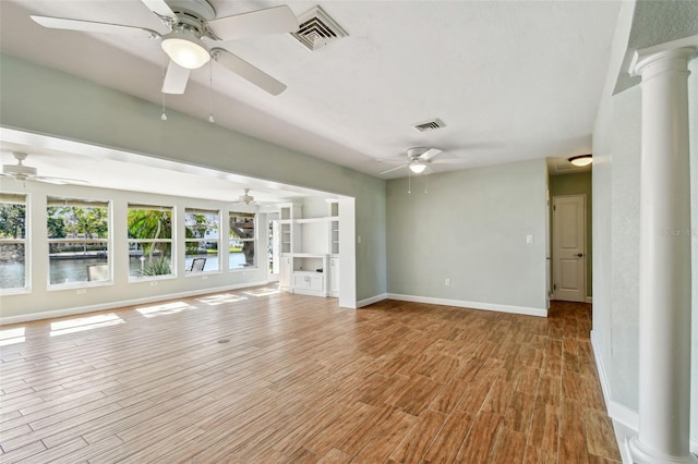 unfurnished living room with a ceiling fan, ornate columns, and visible vents