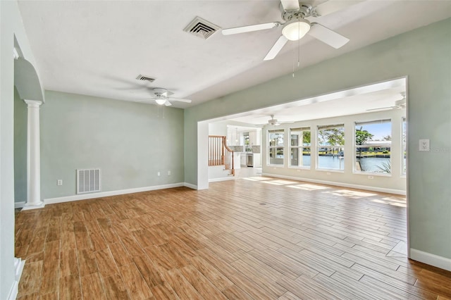unfurnished living room featuring ceiling fan, ornate columns, and visible vents