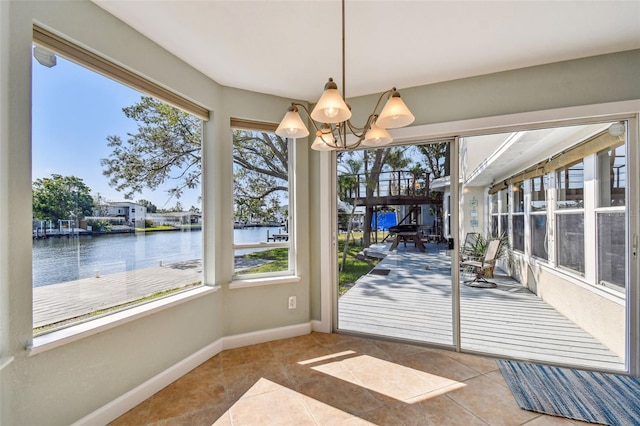 doorway to outside with tile patterned flooring, baseboards, a water view, and a chandelier
