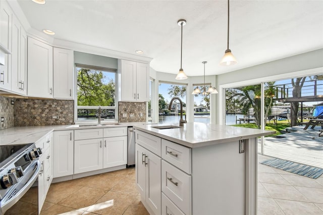 kitchen featuring a sink, tasteful backsplash, light tile patterned flooring, and an island with sink