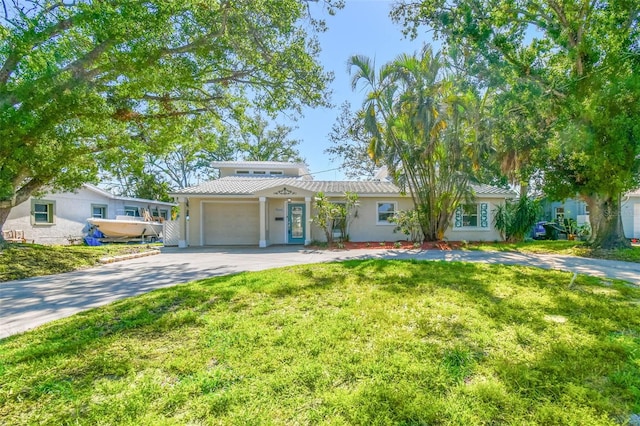 view of front of house featuring an attached garage, aphalt driveway, stucco siding, and a front yard