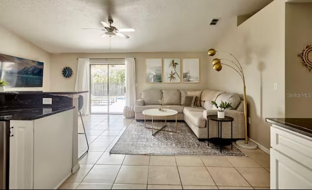 728 Alford St SE, Palm Bay, FL 32909 - living room featuring a ceiling fan, a textured ceiling, visible vents, and light tile patterned floors