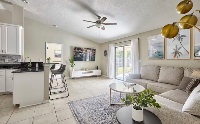 728 Alford St SE, Palm Bay, FL 32909 - living room featuring a ceiling fan, a textured ceiling, vaulted ceiling, and light tile patterned flooring
