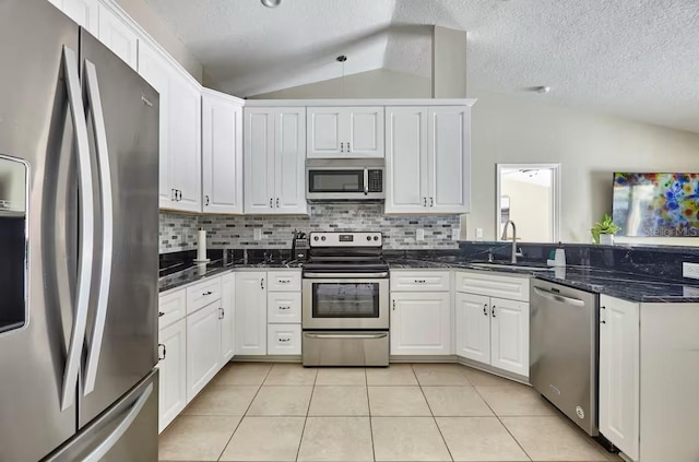 728 Alford St SE, Palm Bay, FL 32909 - kitchen with a textured ceiling, tasteful backsplash, a sink, appliances with stainless steel finishes, and vaulted ceiling