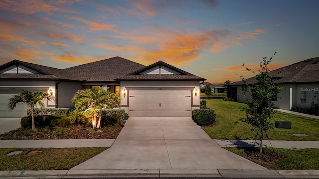 ranch-style home with stucco siding, a garage, concrete driveway, and a front lawn