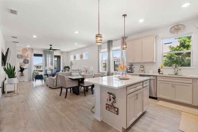 kitchen featuring light wood finished floors, dishwasher, light countertops, a healthy amount of sunlight, and visible vents