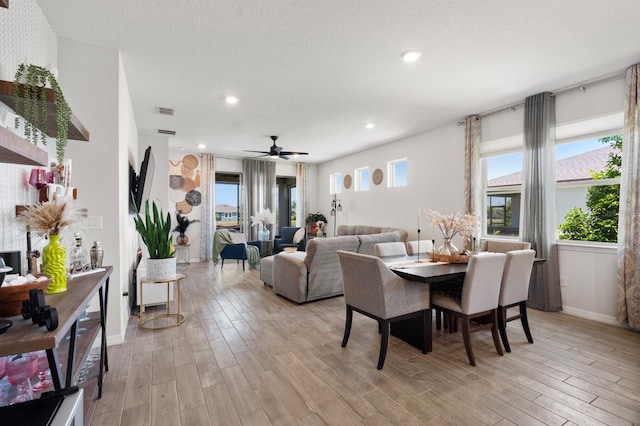 dining space featuring light wood-style floors, baseboards, plenty of natural light, and visible vents