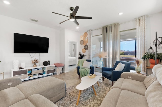 living room featuring a ceiling fan, visible vents, wood finished floors, and recessed lighting
