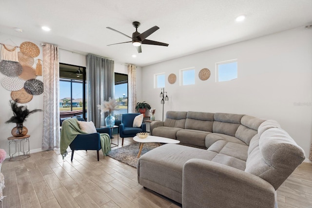 living room featuring a healthy amount of sunlight, ceiling fan, and light wood-type flooring