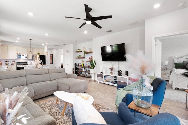 living room featuring recessed lighting, light wood-style flooring, and ceiling fan