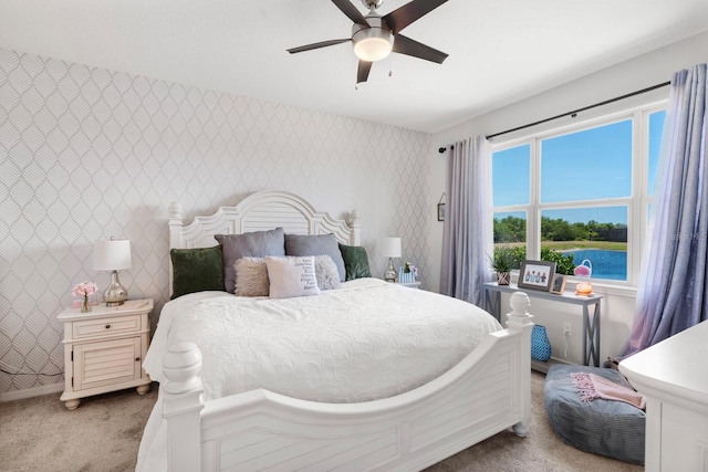 bedroom featuring a ceiling fan, wallpapered walls, light colored carpet, and baseboards