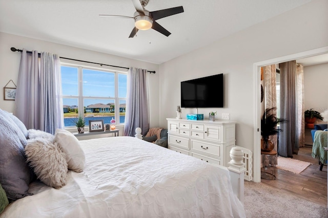 bedroom with a ceiling fan and light wood-style flooring